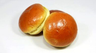 three brioche slider rolls piled together on tabletop